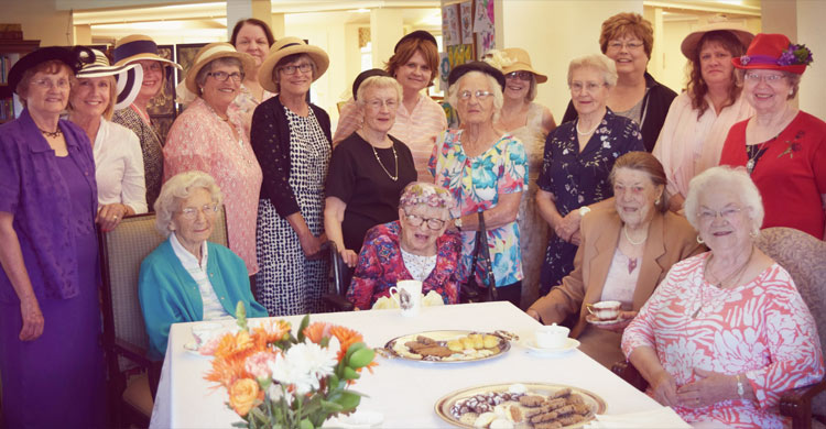 Smiling residents enjoying a tea party at Juniper House Assisted Living & Memory Care